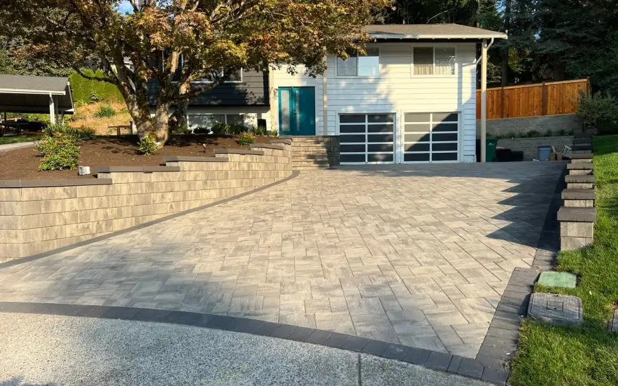 Wide paver driveway and turning apron in front of a garage on a mature Seattle-area lot